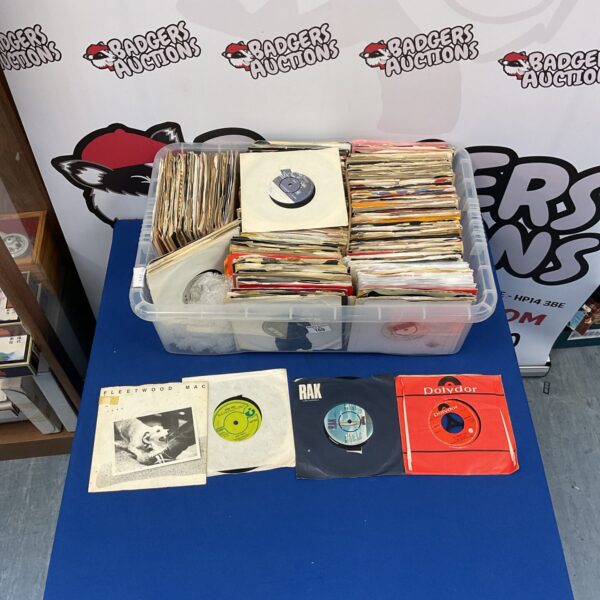 Collection of vintage 1970s vinyl singles in a plastic container.