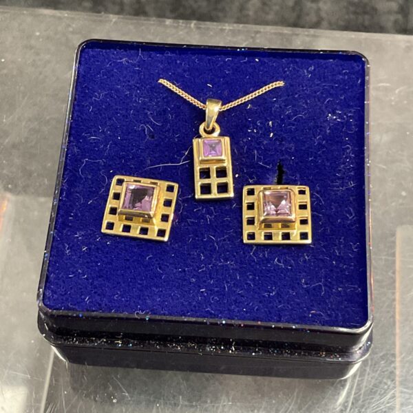 9ct gold amethyst necklace and earrings set on display.