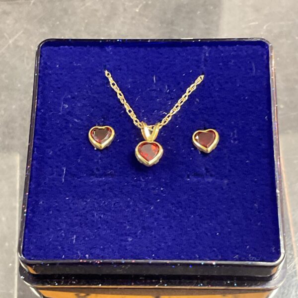 Close-up of 9ct gold garnet heart earrings and pendant necklace.
