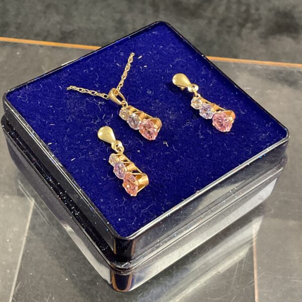 9ct gold necklace and earrings set with three stones displayed.