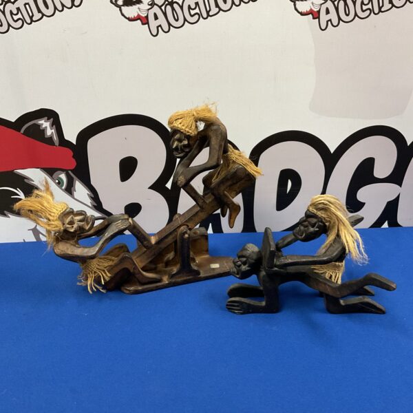 Two African wooden figures on a seesaw, tribal art sculpture.