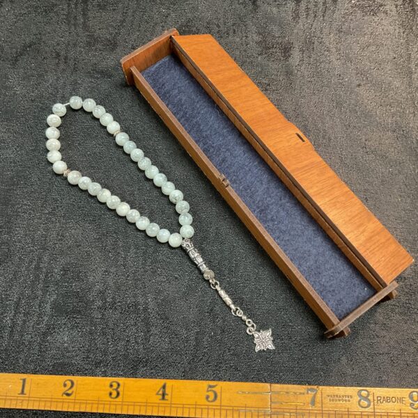Green agate prayer beads in a velvet-lined wooden box.