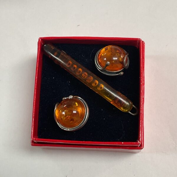Vintage amber brooch with resin cabochon and silver-tone frame.