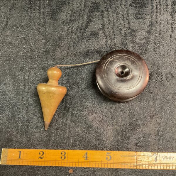 Antique Bakelite plumb bob with brass fitting, vintage surveying tool.
