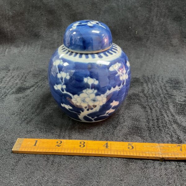 Antique blue and white ginger jar with floral pattern.
