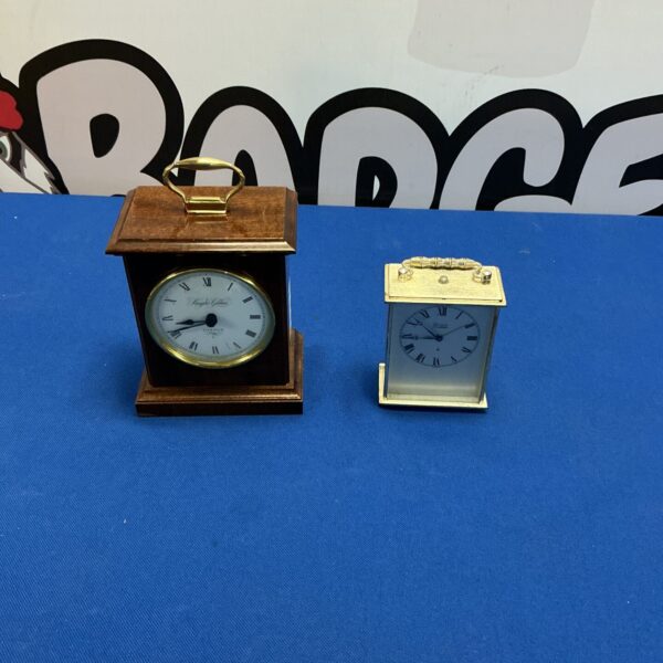 Pair of antique brass carriage clocks on display.