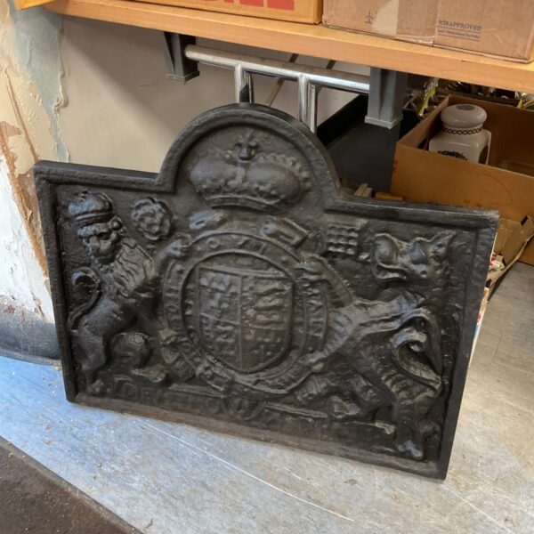 Antique cast iron fireplace back with lion and dragon relief.