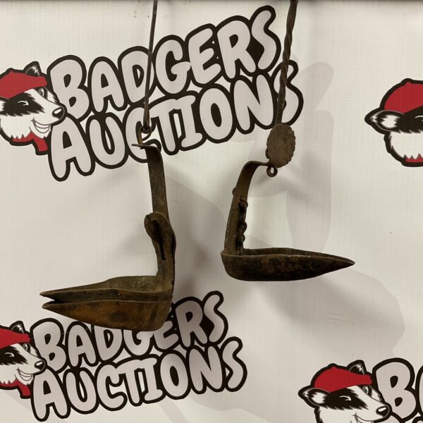 Antique cast iron oil lamp with a curved arm and circular base.