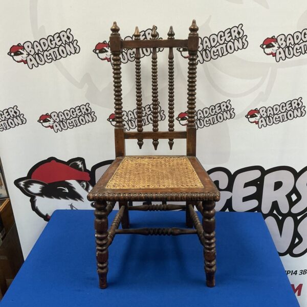 Antique child’s chair with a bobbin back, vintage wooden furniture.