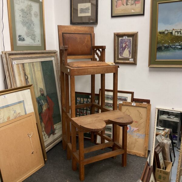 Full view of antique conductors chair with carved details.