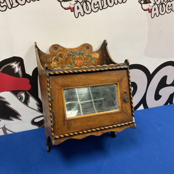 Antique decoupage cabinet shelf with mirrored interior and floral design.