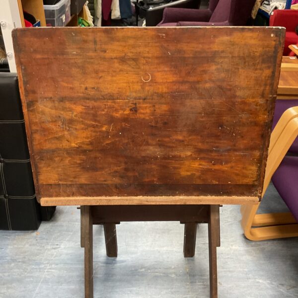 Antique wooden drafting table with adjustable surface.
