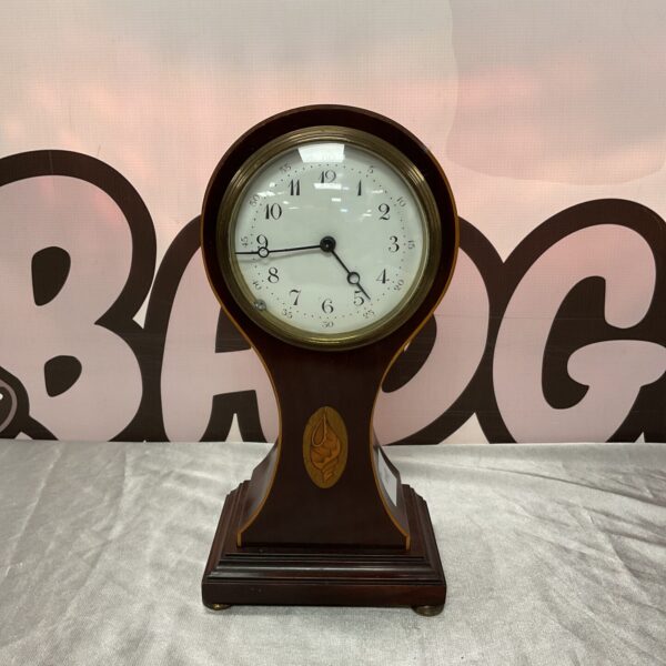 Antique French balloon clock with porcelain body and gilded details.
