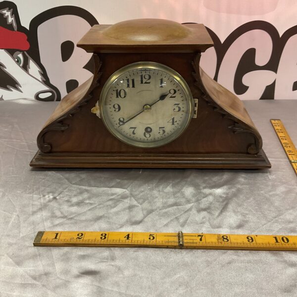 Antique French mantle clock with mahogany case and Roman numeral face.