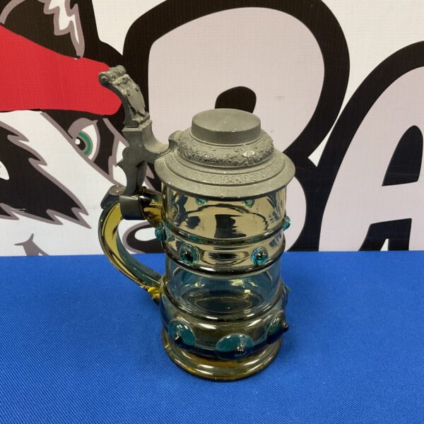 Antique German pewter lidded stein with amber and blue glass.