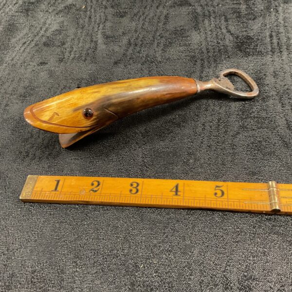 Antique horn bottle opener with amber handle, vintage barware.