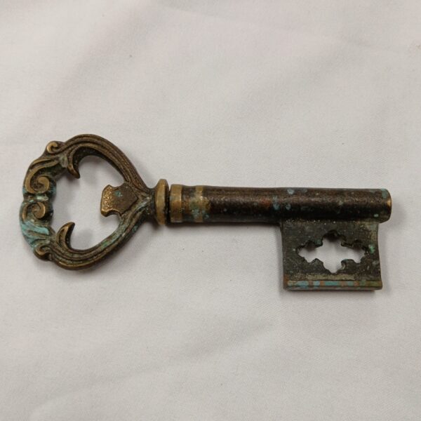 Antique key corkscrew with dark patina, vintage wine opener.