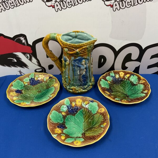 Antique majolica plates and jug set with floral designs.