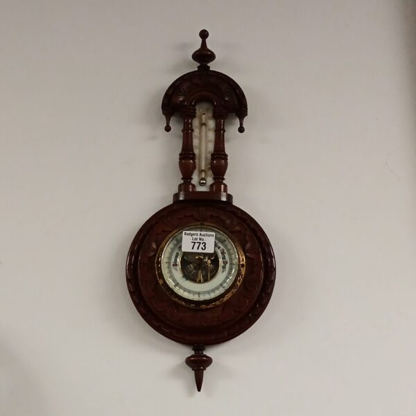 Antique oak cased barometer with circular dial and thermometer.