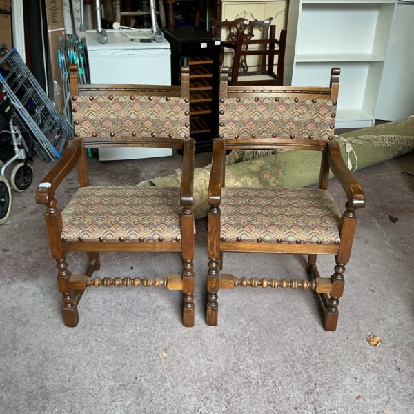 Pair of antique oak carver chairs with carved details.