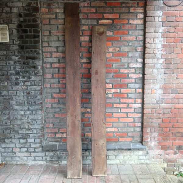 Antique ship planks against brick wall, nautical history.