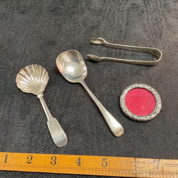 Antique silver cutlery set including spoon, tongs and frame.