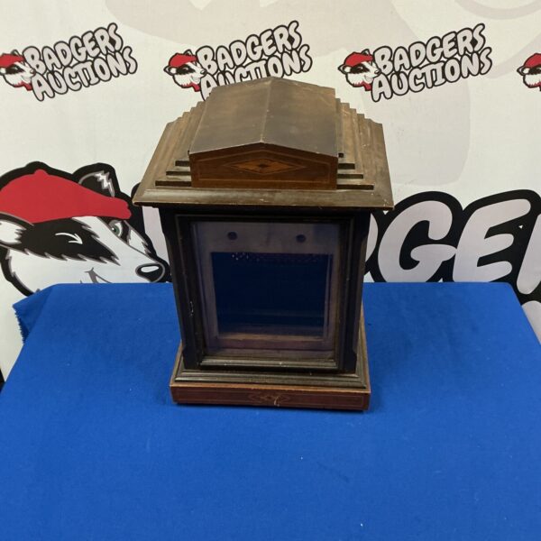 Front view of antique wooden clock case with recessed face.