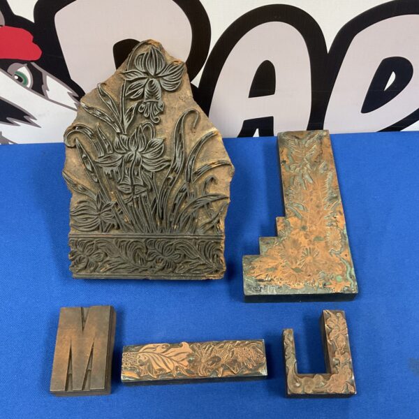 Intricate Art Nouveau printer block with floral design in copper relief.