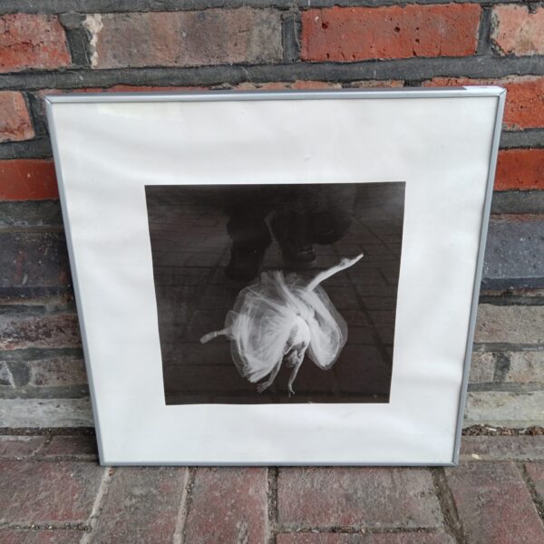 Framed black and white photograph of a graceful ballerina in motion.