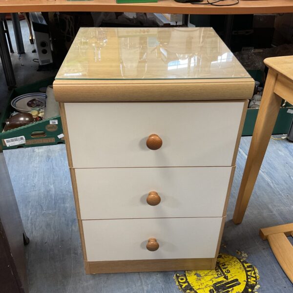 Front view of a beech bedside cabinet with three drawers.