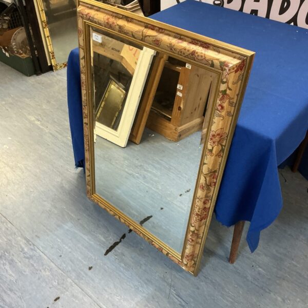 Ornate gold framed bevel edge mirror for wall decor.