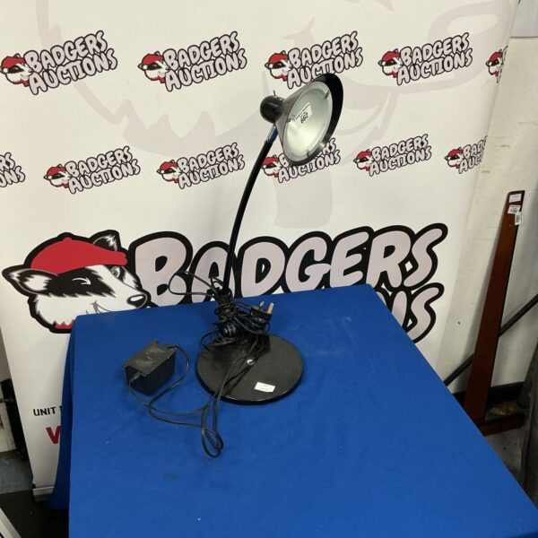 Black adjustable reading lamp on a white surface.