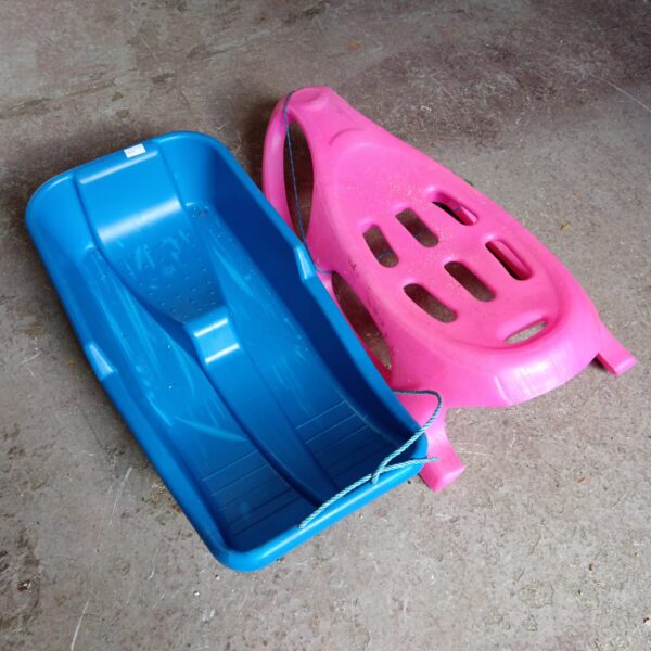 Blue plastic children’s sledge for winter snow fun.