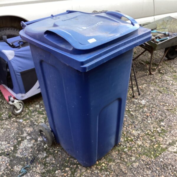 Blue recycling wheelie bin for garden or outdoor use.