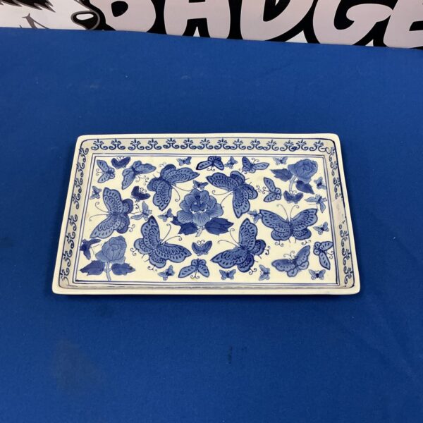 Delicate blue and white pottery tray with butterfly design.