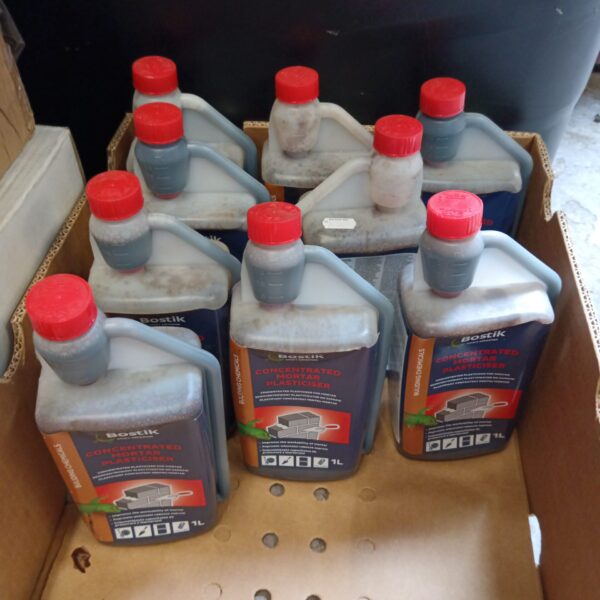 Nine bottles of Bostik concentrated mortar plasticiser for masonry work.