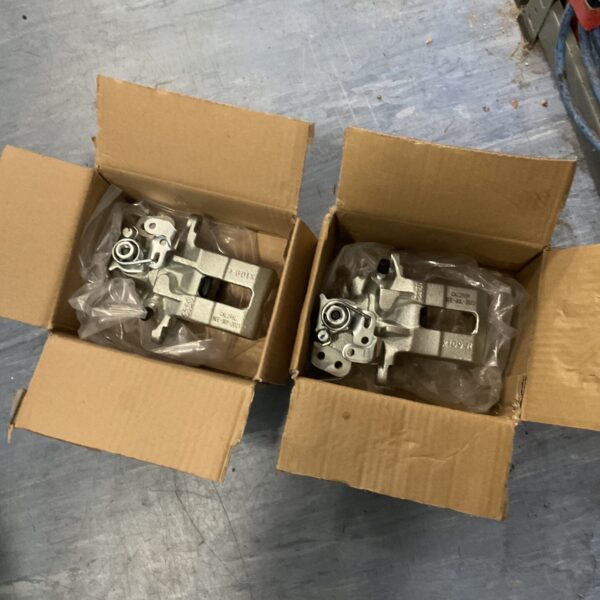 New brake calipers in original packaging for automotive repair.