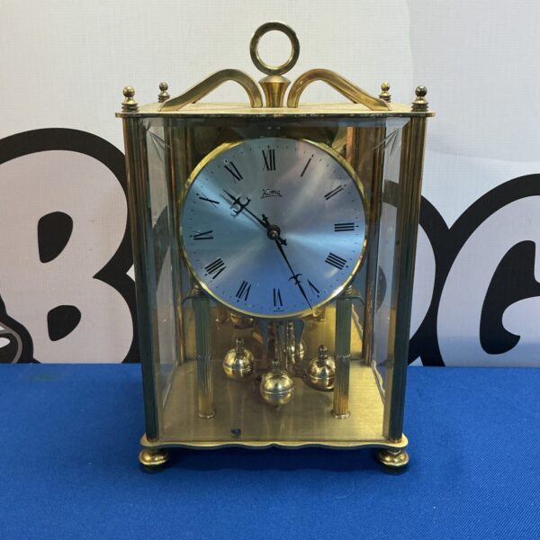 Vintage brass and glass mantle clock with Roman numerals.