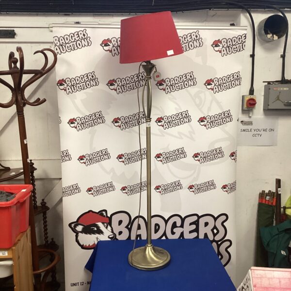 Vintage brass standard lamp with a red shade.