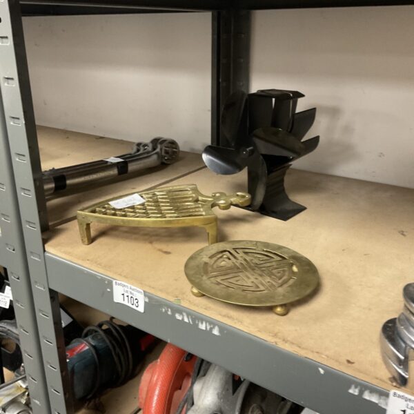 Vintage brass trivets and heat conduction fan for kitchen decor.
