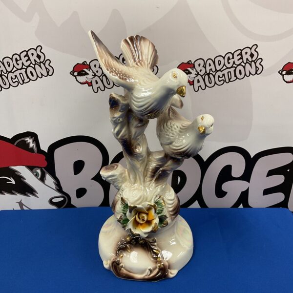 Detailed Capodimonte porcelain sculpture of doves on a flowering branch.