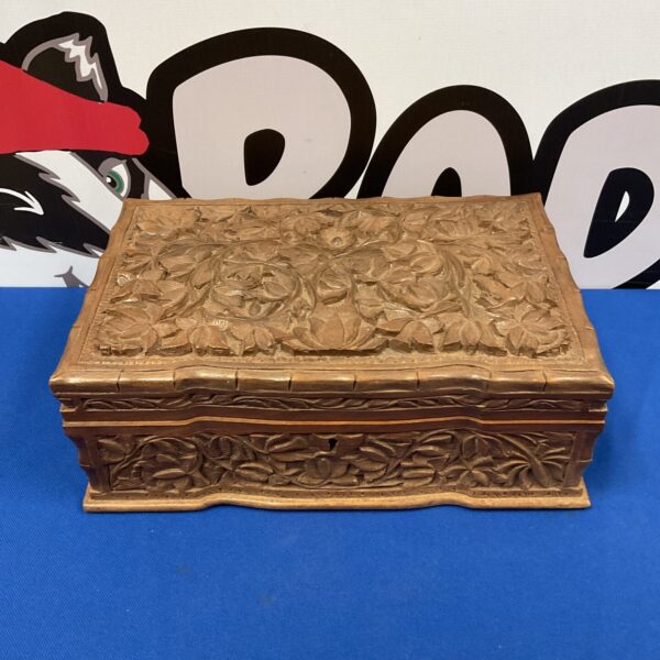 Intricate carved wooden jewellery box with floral design.