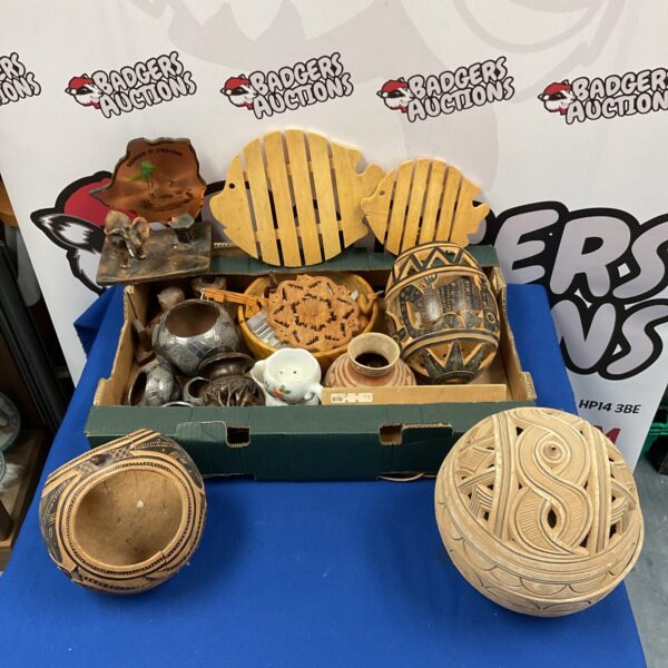 Carved wooden tray displaying African basket and decorative vase.