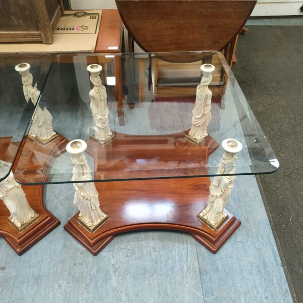 Pair of Caryatid accent tables with glass tops and sculpted bases.