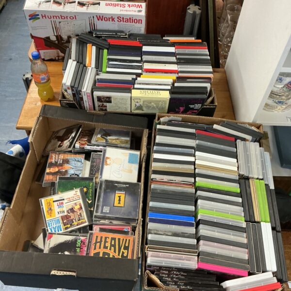 Large collection of CDs and DVDs in trays, entertainment media lot.