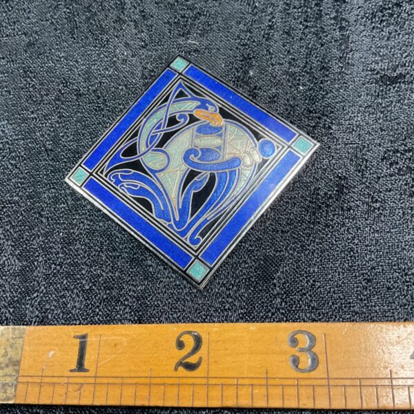 Vintage Celtic cloisonné brooch with a blue mythical creature design.