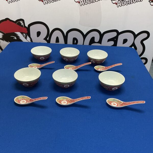 Vintage set of six China rice bowls with spoons on display.