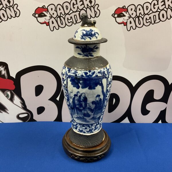 Antique Chinese blue and white porcelain temple vase on blue surface.