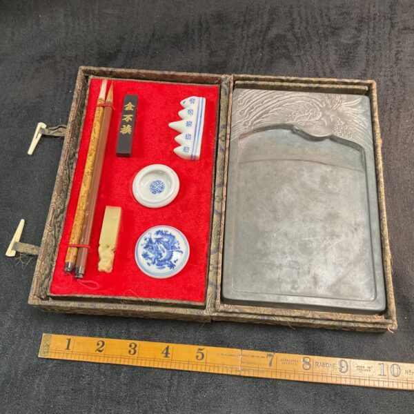 Open Chinese calligraphy set with brushes and slate tray.