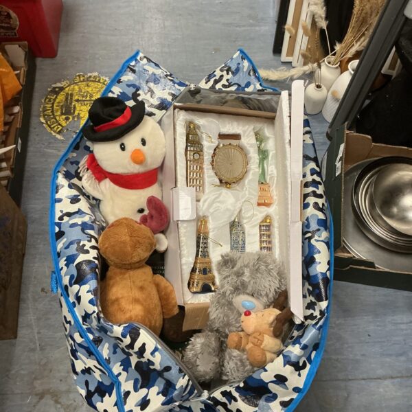 A colourful bag filled with a variety of Christmas decorations and soft toys.